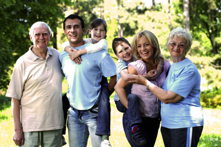 Extended happy family standing in the park.